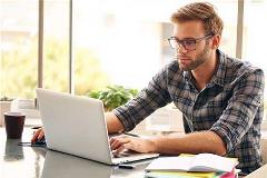 Man on home laptop reviews online investing